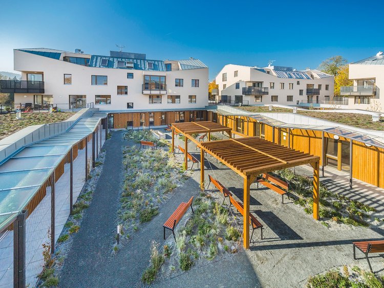 Photo: modern residential building with green spaces in the middle, fitted with high-quality wooden elements