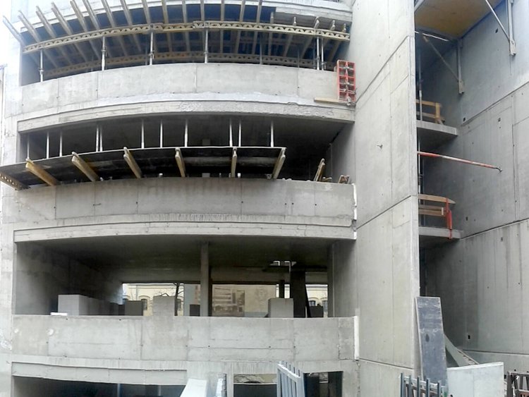 Photo: structural work consisting of partly swinging reinforced concrete slabs, sections of scaffolding and site facilities